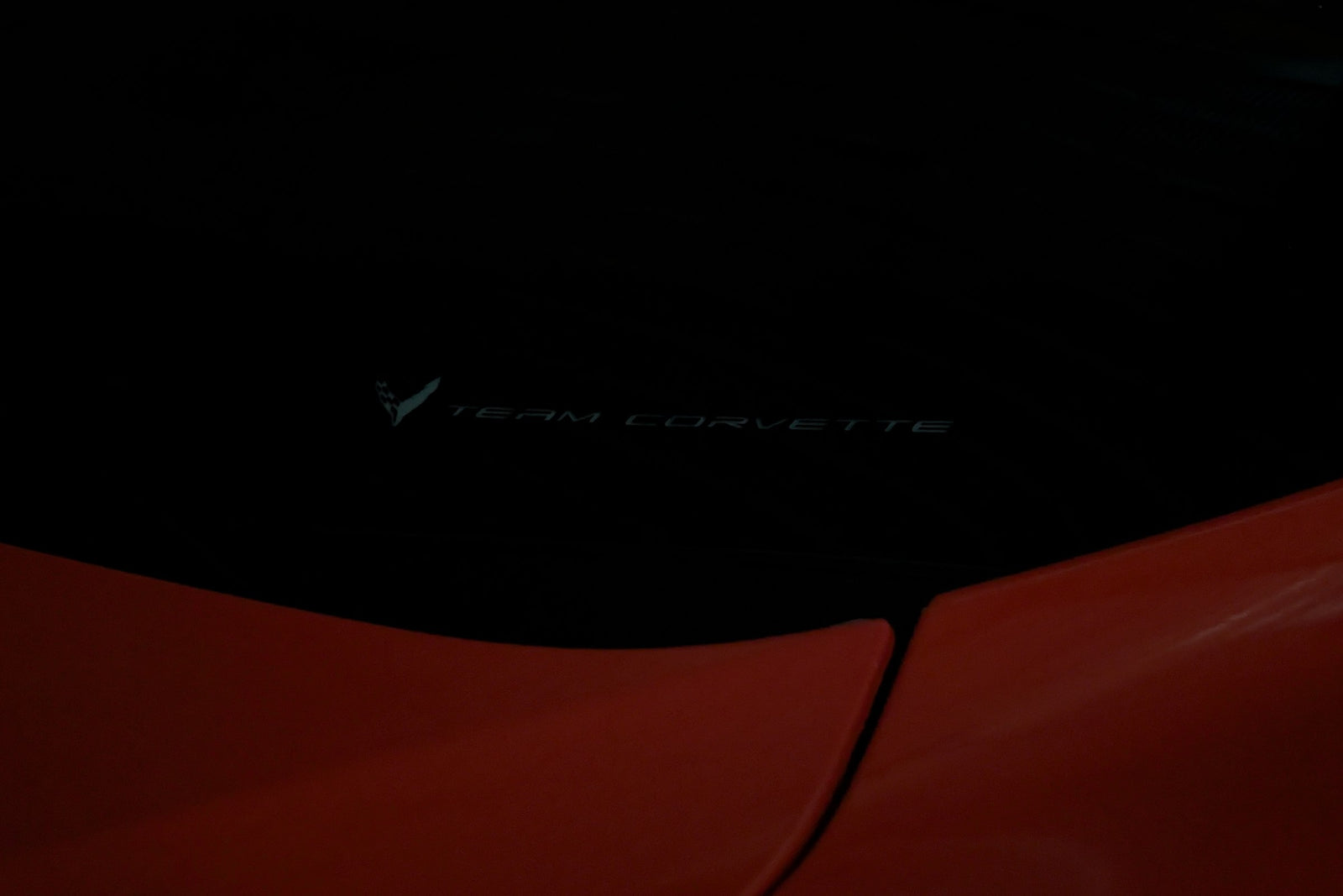 Team Corvette windshield emblem unlit, showing the factory etching in the glass of a Corvette C8